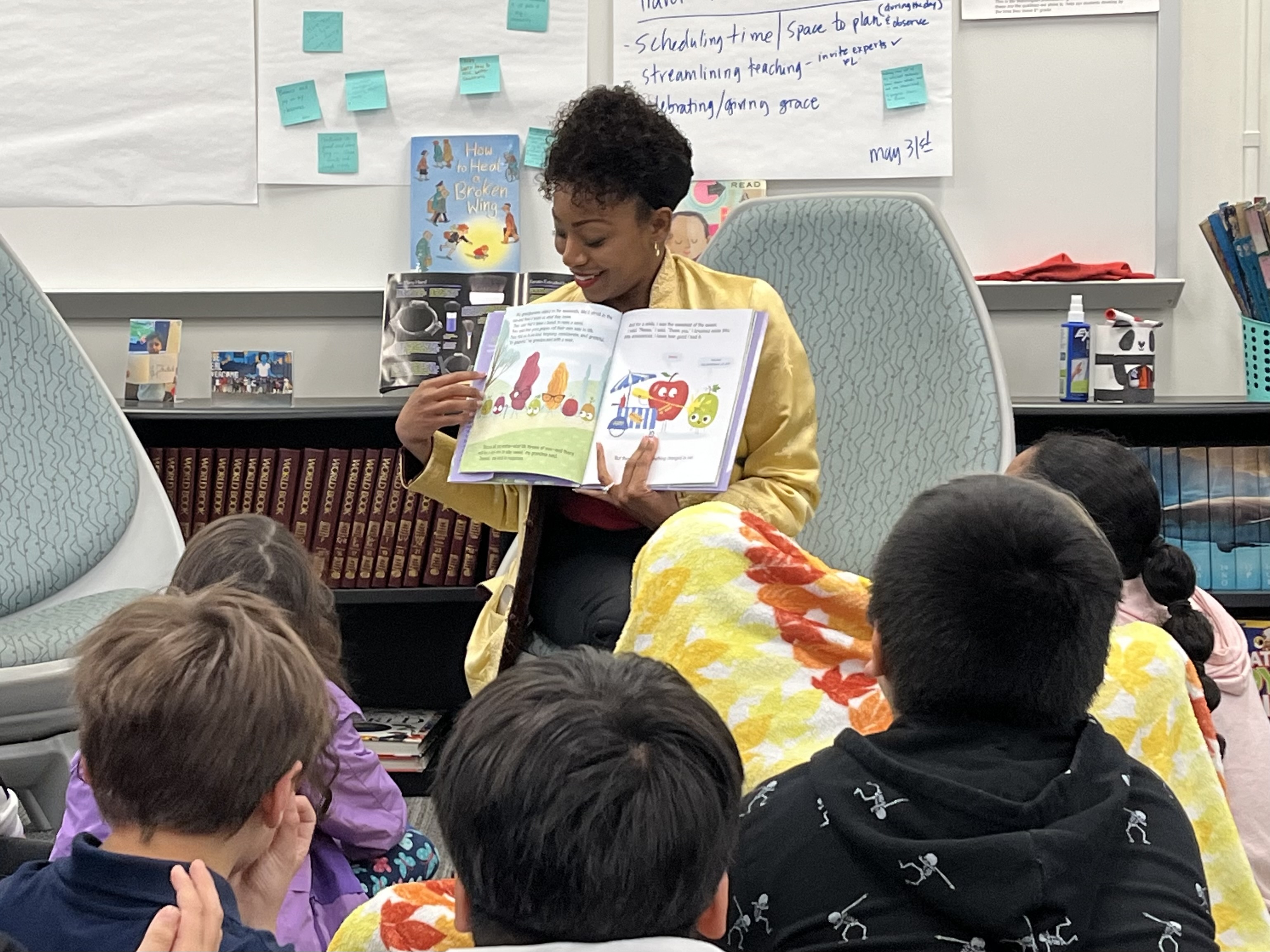 Photo showing Controller Malia Cohen seated in a classroom reading to elementary school kids for a Read Across America event.